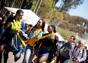 Three students laughing walking down Library Walk